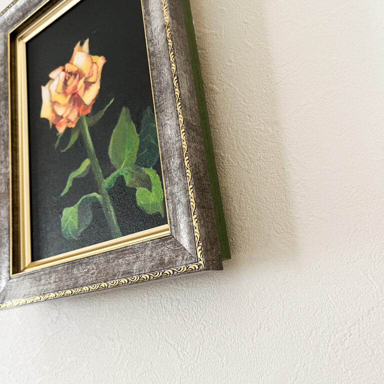 オレンジ色の薔薇を描いたアクリル画。額装された作品を下から撮影し、質感と奥行きがわかる構図。